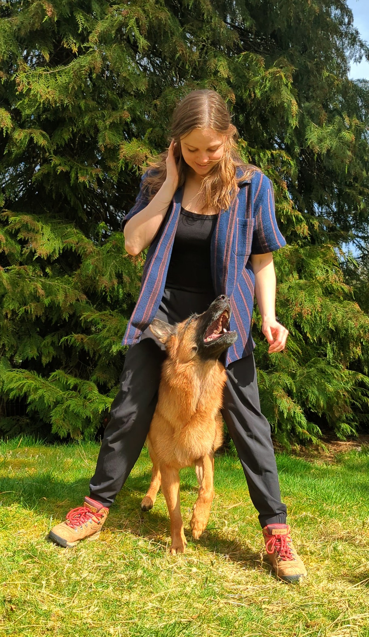 girl looking down at german sheperd standing between legs looking up at her