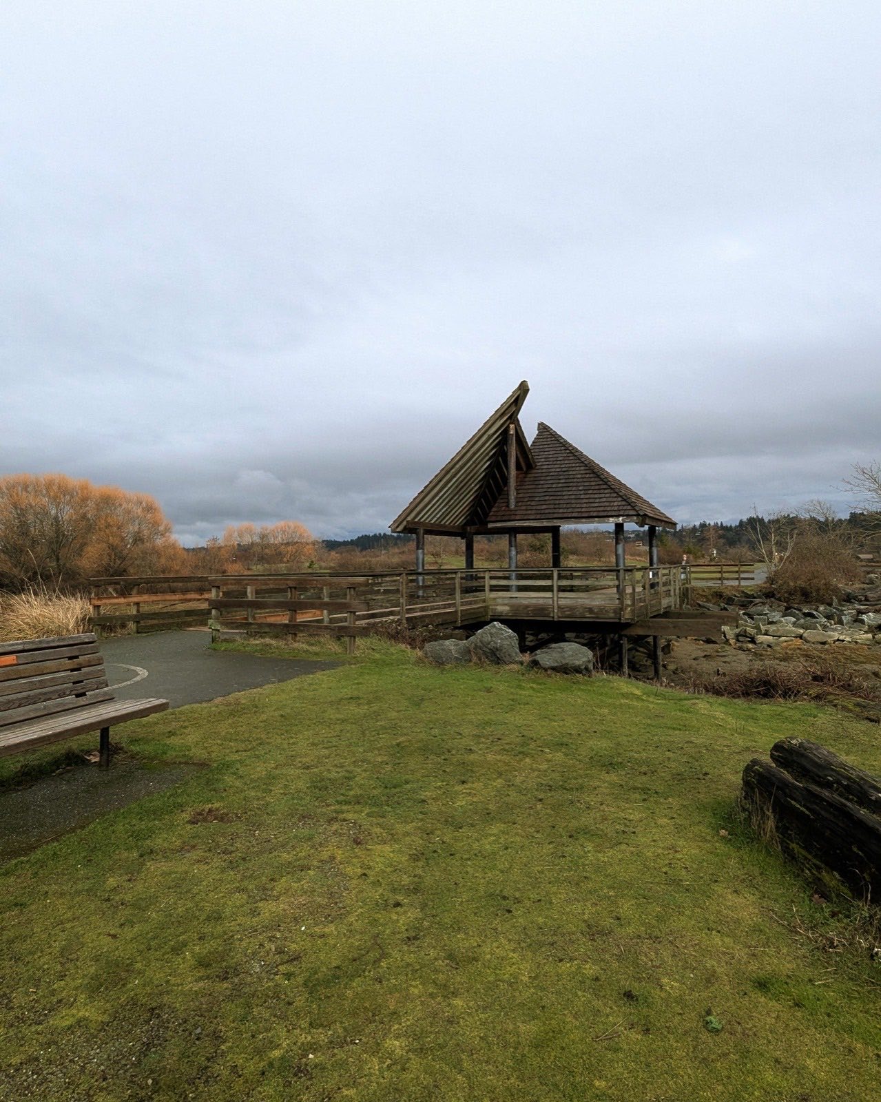 green grass with bench and asymmetrical gazebo in background